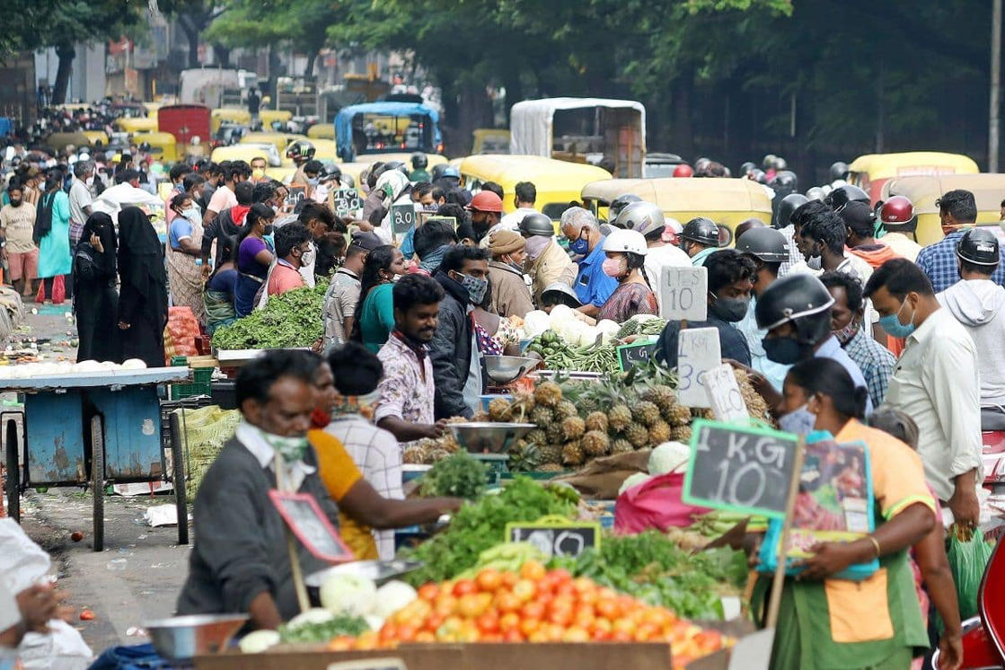 a group of people looking at a fruit stand: Massive crowding was seen at various markets in Delhi.