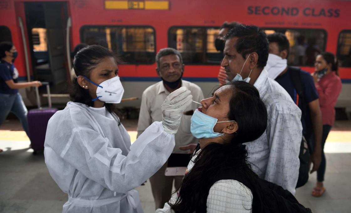 MUMBAI, INDIA - JUNE 18: A BMC health worker collects a swab sample of a passenger for Covid-19 testing, at Dadar Station, on June 18, 2021 in Mumbai, India. (Photo by Satish Bate/Hindustan Times via Getty Images)