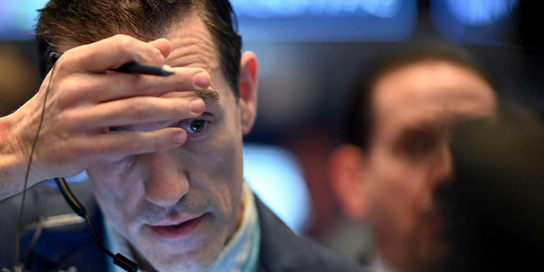 a close up of a man: Global stocks pull back from record highs as COVID-19 cases rise at the fastest rate since the pandemic began