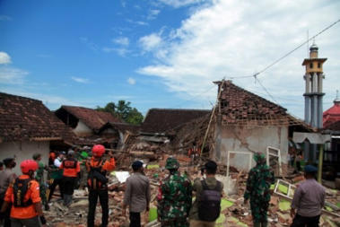 a group of people standing in front of a building: 6.4-magnitude quake hits Indonesia