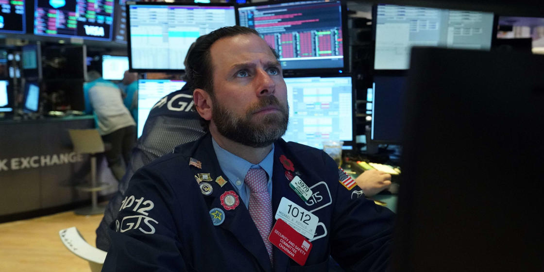 a man wearing a suit and tie: Dow tumbles 257 points as spike in COVID-19 cases spurs economic-recovery concern