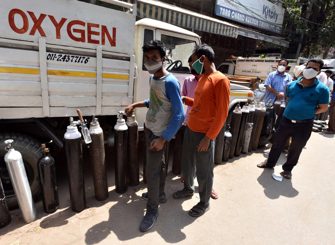 NEW DELHI, INDIA - APRIL 26: Family members of patients stand with empty oxygen cylinders outside the oxygen filling center at Bhogal on April 26, 2021 in New Delhi, India.